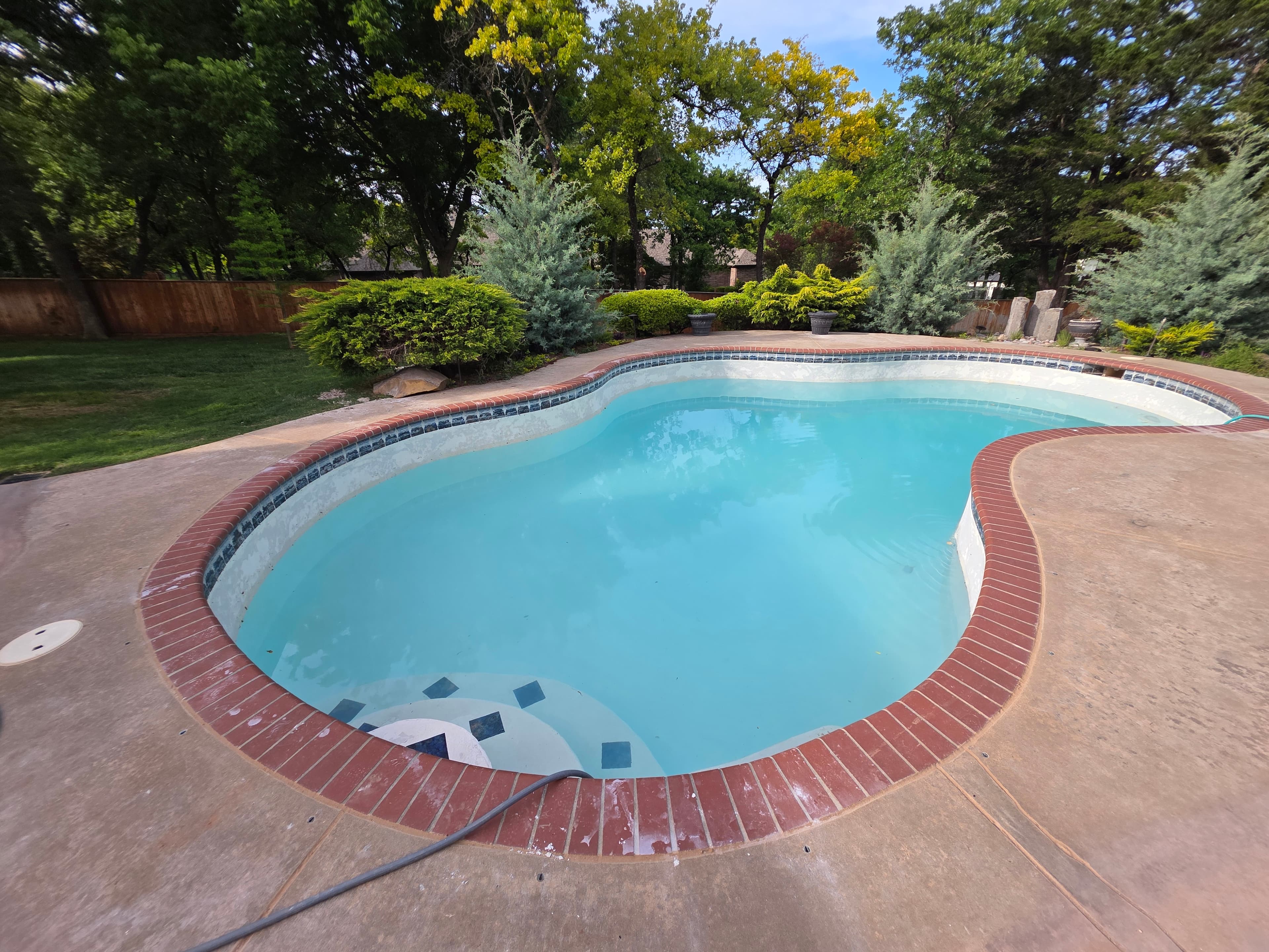 Swimming pool being restored from green algae water to crystal clear condition.